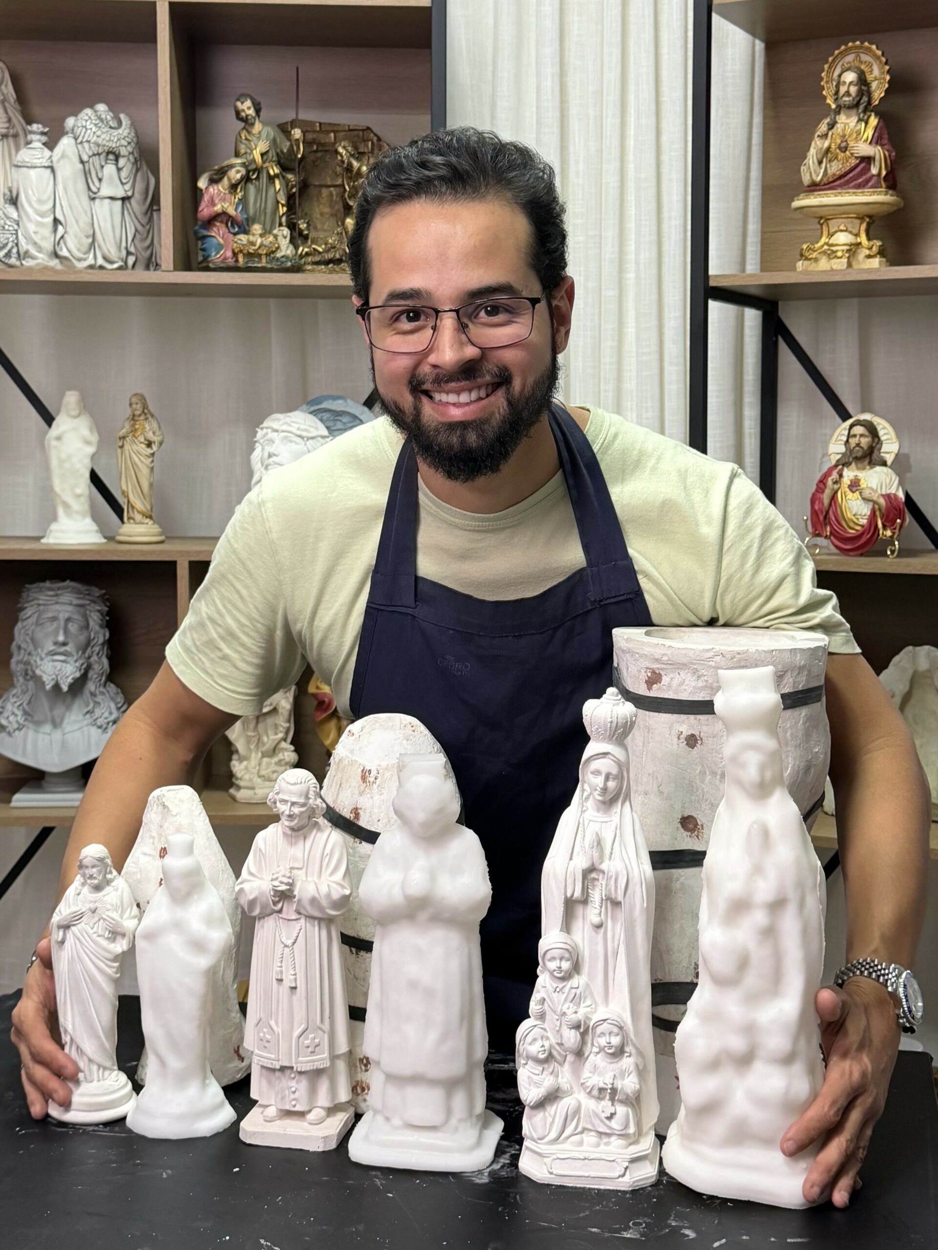 Pedro Freitas no ateliê segurando uma peça sacra